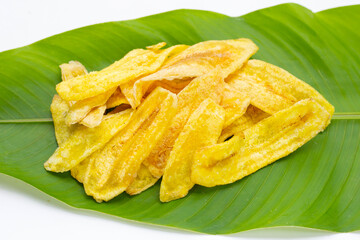Banana slice chips on green leaf on white background.