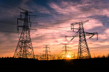 A silhouette of an electric tower against a beautiful sunset background