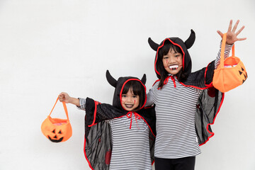 happy Halloween! two children in Halloween costumes and with pumpkins on white background
