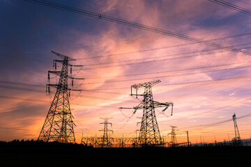 A silhouette of an electric tower against a beautiful sunset background