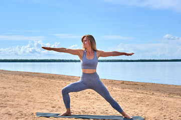 Fototapeta na wymiar Woman doing yoga on the sandy beach