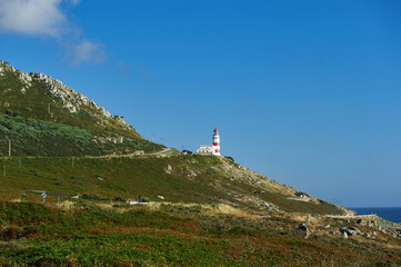 Fototapeta na wymiar the lighthouse of cabo silleiro in the middle of a mountain slope on the coast