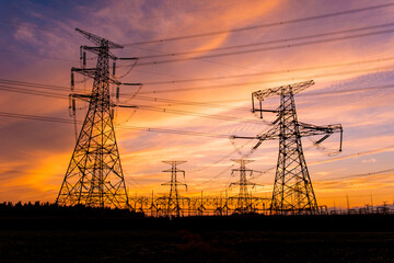 A silhouette of an electric tower against a beautiful sunset background