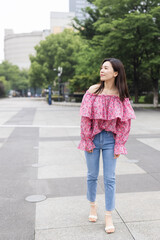 Portrait of young asian woman wearing stylish casual clothing and walking outdoor in city. Happy stylish woman with smiley face enjoys life