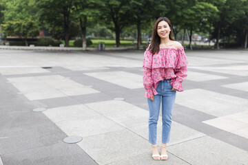 Portrait of young asian woman wearing stylish casual clothing and walking outdoor in city. Happy stylish woman with smiley face enjoys life