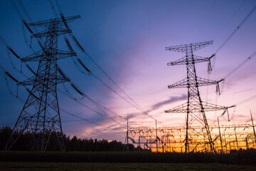 A silhouette of an electric tower against a beautiful sunset background
