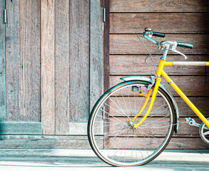 Fototapeta premium vintage yellow bicycle on old wooden wall background.lifestyle concept idea