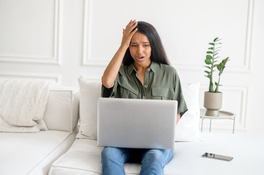 Upset And Frustrated Young Indian Woman Using Laptop For Remote Work From Home, Nervous About Mistakes, Stressful Job, Mixed-race Female Student Has Problem With Task Holding Head With Desperation