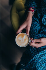 woman holding cup of coffee with latte art espresso