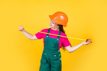 Smart professional. building and construction. concept of repair. Little girl use measuring tape. engineer. happy child hold tape measure. kid builder wear helmet. teen girl in hard hat and uniform