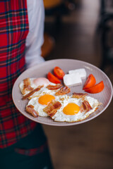 fried eggs in a plate, breakfast hands holding.