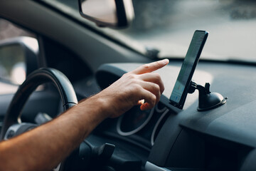 Navigator in car vehicle transportation commuter. Driver man pointing hand finger mobile phone navigator app while driving car. - 455065365