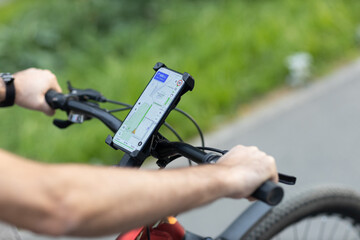 Man planning route using GPS navigation application in mobile phone on his bicycle bike - Powered by Adobe