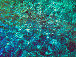 Abstract background of sea water with ripples on surface. Textured backdrop in mixed blue, azure, teal and green sea tints.