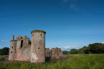 Fototapeta na wymiar Caerlaverock Castle, Dumfries and Galloway, Scotland, in sunshine with blue sky, no people. Lots of copy space above in sky area.