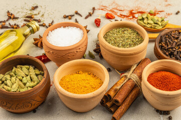 A set of spices for cooking curry. Aromatic condiments on light stone concrete background
