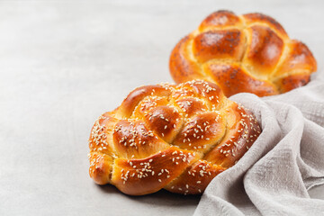 Homemade rose braid bread with sesame seeds and poppy seeds. Light grey background, copy space.
