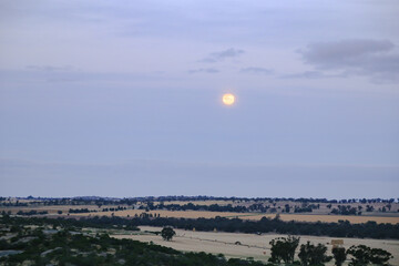 Blood moon rising over rural Australian landscape