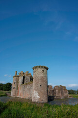 Fototapeta na wymiar Vertical orientation of Caerlaverock Castle, Dumfries and Galloway, Scotland, in sunshine with blue sky, no people. Lots of copy space above in sky area.