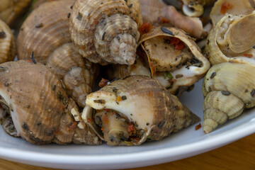 assiette de bulots cuits sur une table