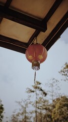Fototapeta na wymiar a lantern hanging on the roof. traditional decoration for chinese events. a red lantern placed in the outdoor building.