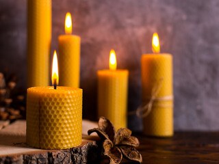A handmade of natural wax with texture of honeycomb bees candles burns on the table, an unusual element of the interior.