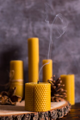 A handmade candle made of natural wax with the texture of honeycomb bees. Extinct smoke on the table.