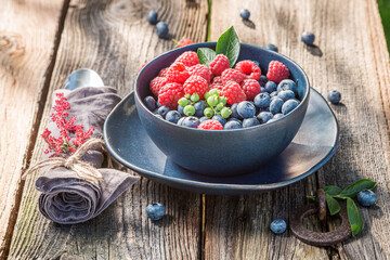Fresh berries, cutlery and napkins in summer garden