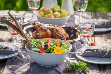 Tasty dinner with chicken served in countryside. Dinner in garden.