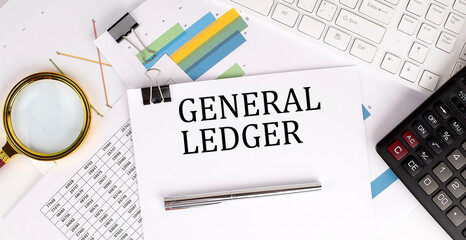 GENERAL LEDGER text on the white paper on the light background with charts paper ,keyboard and...
