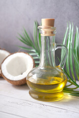 slice of fresh coconut and bottle of oil on a table 