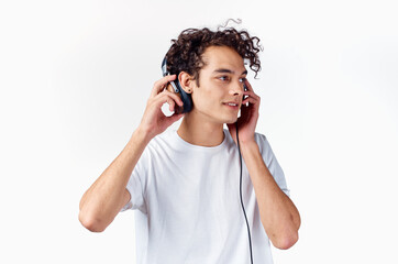 curly-haired guy in white t-shirt with headphones music technology entertainment