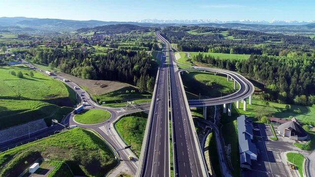 New highway in Poland on national road no 7, E77, called Zakopianka.  Overpass junction with a traffic circle, viaducts, slip roads, cars near Skomielna Biala. Aerial view. Far view of Tatra Mountains