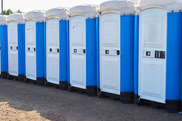 Row of portable toilets at an outdoor event