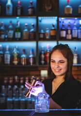 Portrait of young attractive woman bartender Making Cocktail in bar