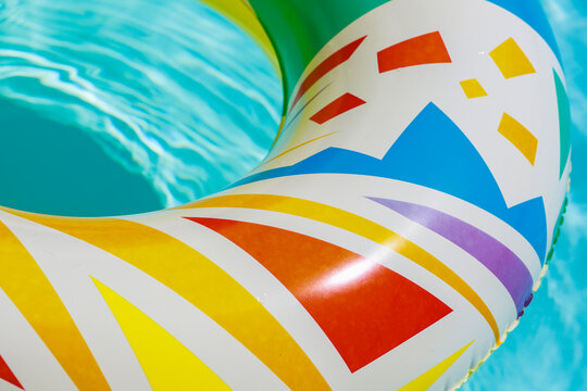 Partial image of colorful plastic lifebuoy seen from above in the swimming pool.