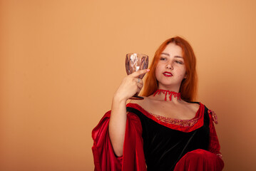 The red-haired countess is a witch of European witch with a decanter in her hands in isolation. The concept of the holiday of evil spirits Halloween