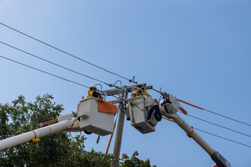 Power electrical lines support servicemen handling damage after hurricane