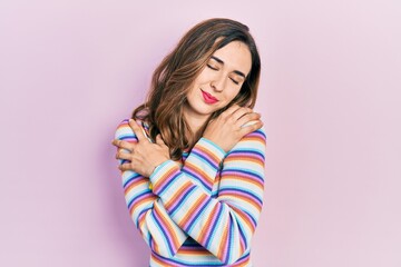 Young hispanic girl wearing casual clothes hugging oneself happy and positive, smiling confident. self love and self care