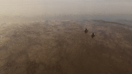 Aerial shot of two motorcyclist driving over water after strong rain in Argentina. Flooded fields...