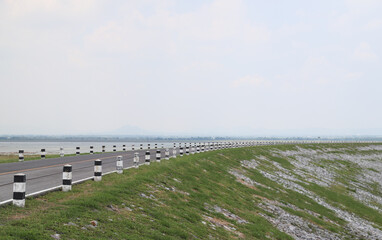 Closeup of traffic regulating poles beside the road on the dam with natural background.