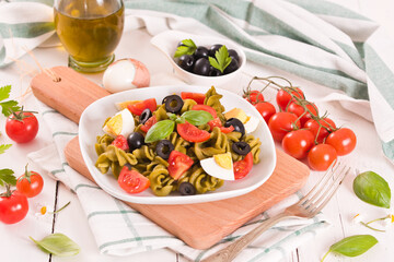 Fusilli pasta with cherry tomatoes, eggs and black olives.