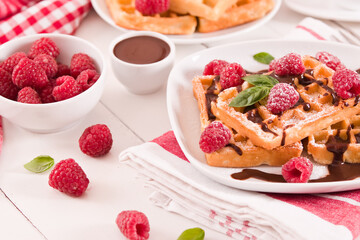 Waffles with raspberries and chocolate cream.