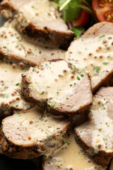 Roast Pork Tenderloin in mustard gravy with vegetables and potato wedges