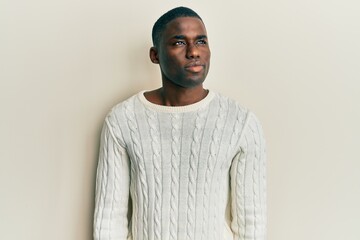 Obraz premium Young african american man wearing casual clothes smiling looking to the side and staring away thinking.