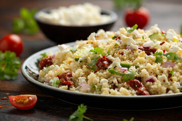 Couscous salad with sun dried tomatoes, cucumber, red onion and feta cheese. healthy food.