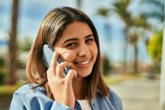 Young latin girl smiling happy talking on the smartphone at the city.