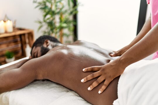 African American Man Reciving Back Massage At The Clinic.