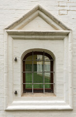 Fototapeta na wymiar Window of an old brick building with iron bars