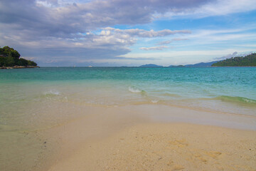 Fototapeta premium Tropical white sand beach o n island with mountain sea view